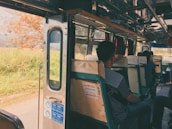 Interior view of a spacious bus with comfortable seats and large windows showing passing landscapes.