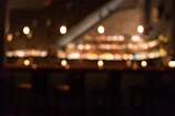Partial view of a dimly lit dining scene with blurred silhouettes