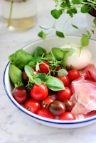 Fresh ingredients laid out: ripe tomatoes, basil, mozzarella, and olive oil.