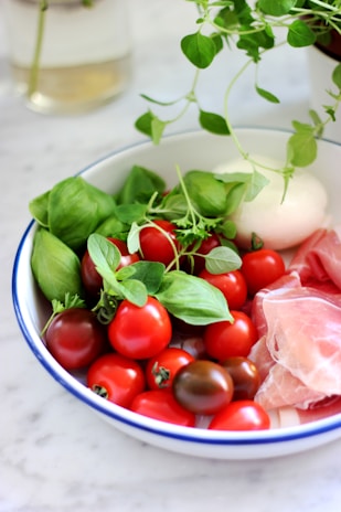 Close-up of creamy buffalo mozzarella balls on rustic wooden board with fresh basil leaves.