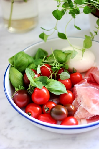 Close-up of creamy buffalo mozzarella balls on rustic wooden board with fresh basil leaves.