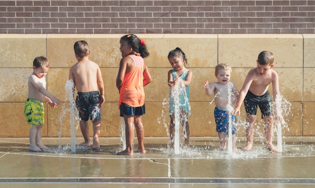 five children playing water during day time