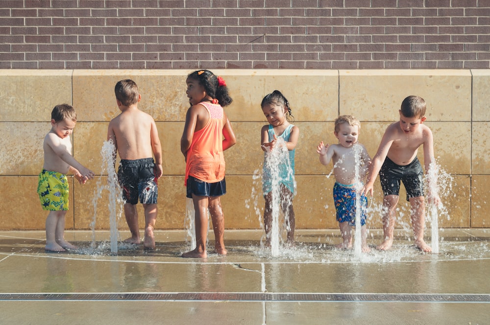 five children playing water during day time