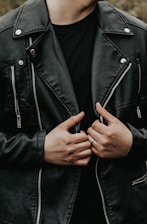 man holding his leather jacket