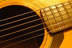 Close-up of hands playing a classic acoustic guitar with warm wood tones