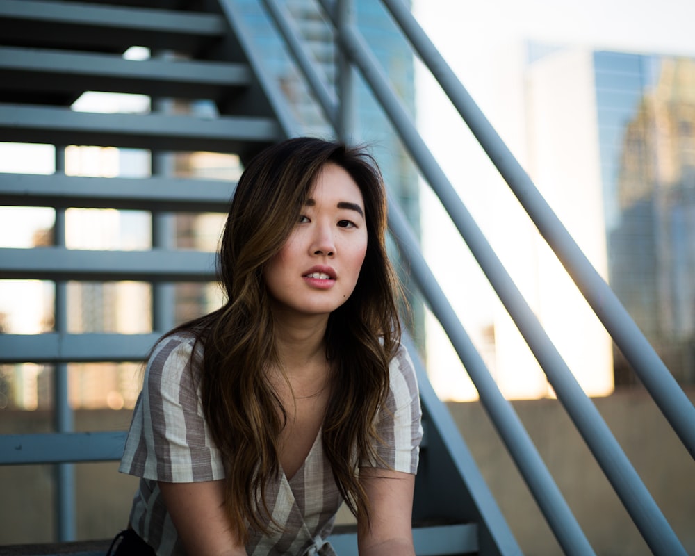 woman sitting on white metal stairs