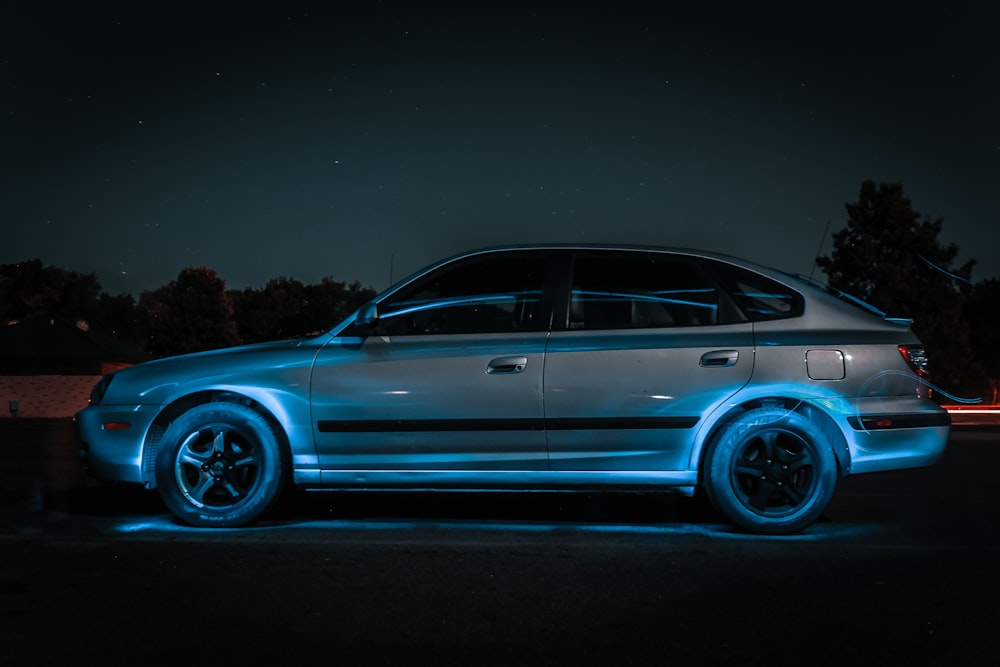 silver sedan park on road with blue lights
