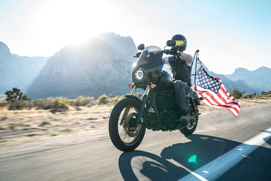 fanning photography of man riding cruiser motorcycle near mountain in Downtown United States