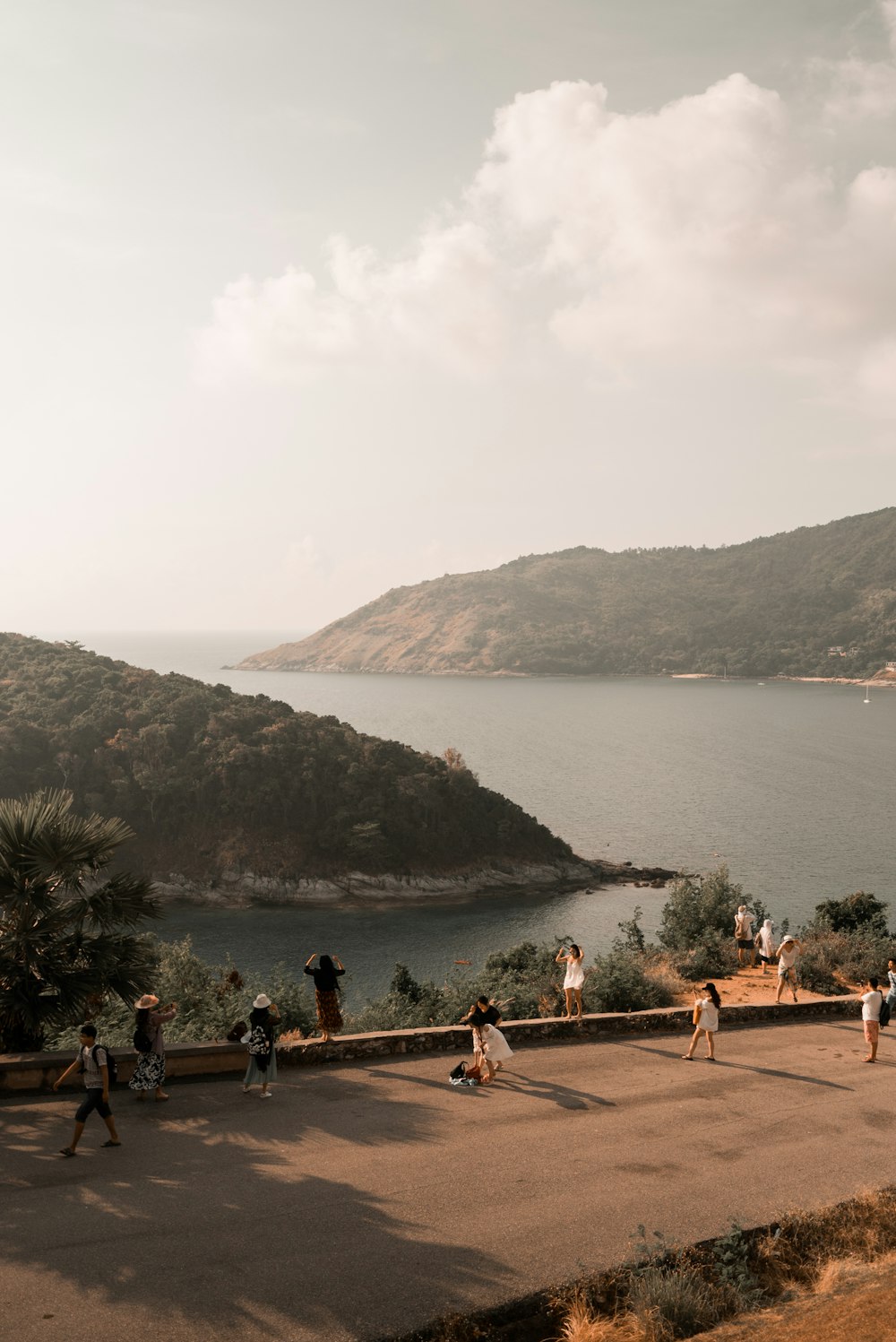 people on concrete road near body of water