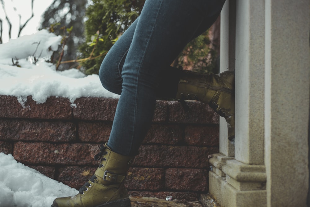 woman leaning against wall right legs on wall