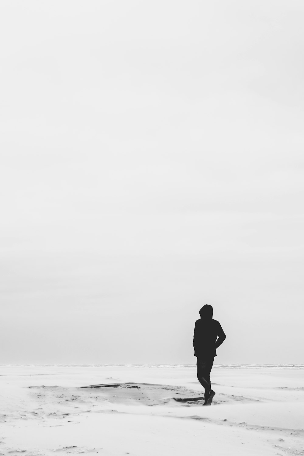 Mann im Kapuzenpullover, der tagsüber auf schneebedecktem Feld steht