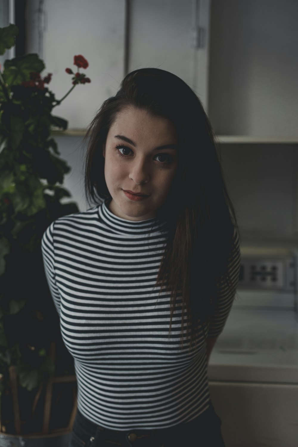 woman standing near tall indoor plant