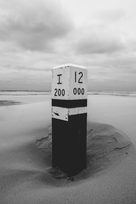 grayscale photography of signage on shore in Ameland Netherlands