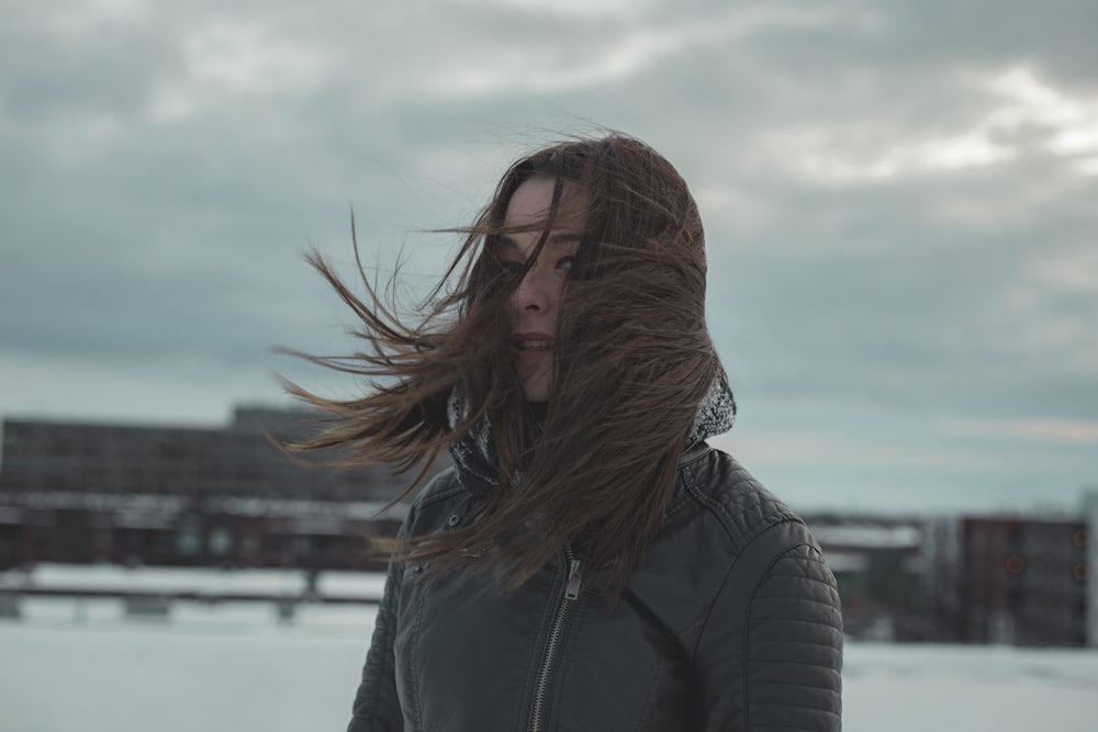 woman standing while hair is blown by wind