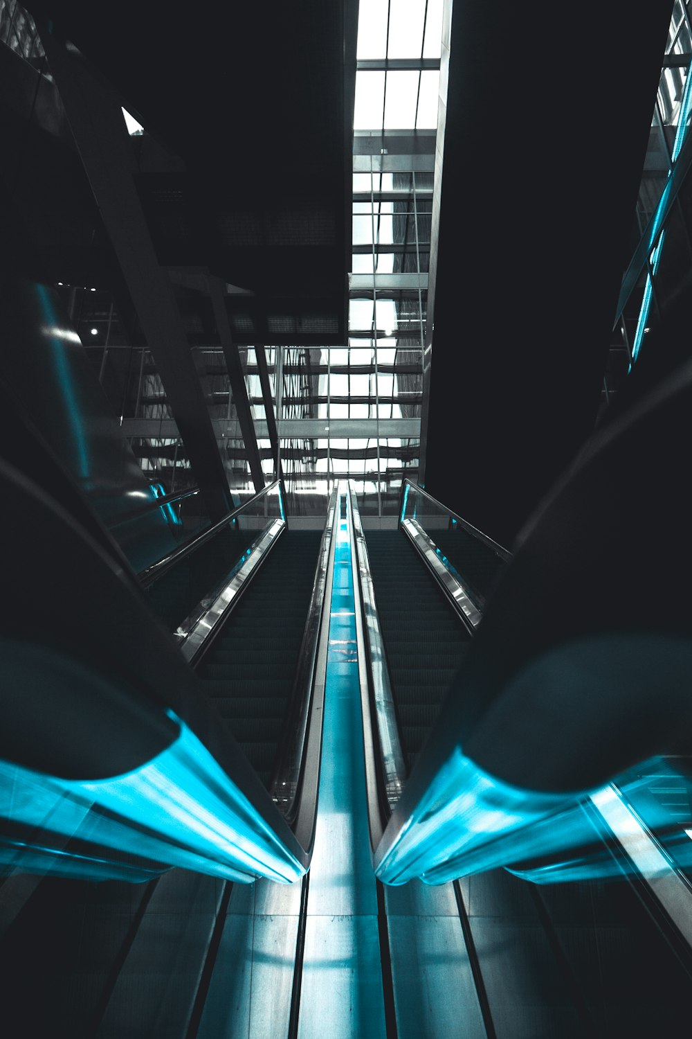 an escalator in a building with blue lights