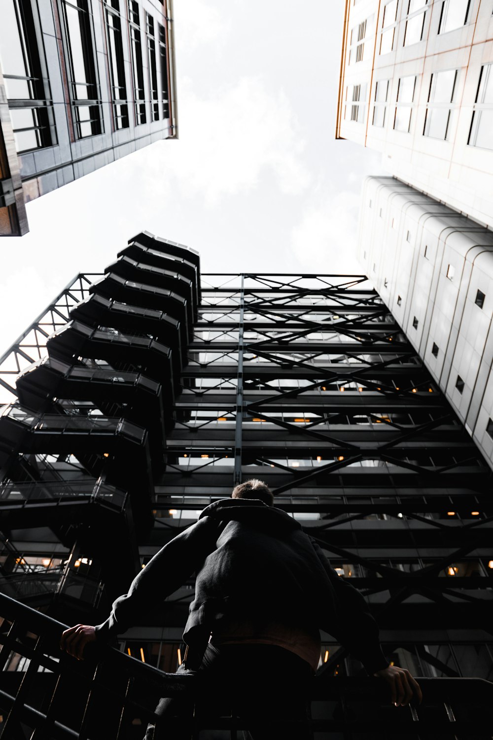 photo of man standing in front of black high-rise building