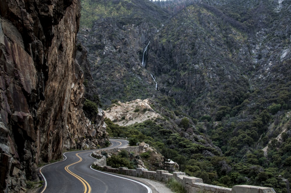 asphalt road beside cliff