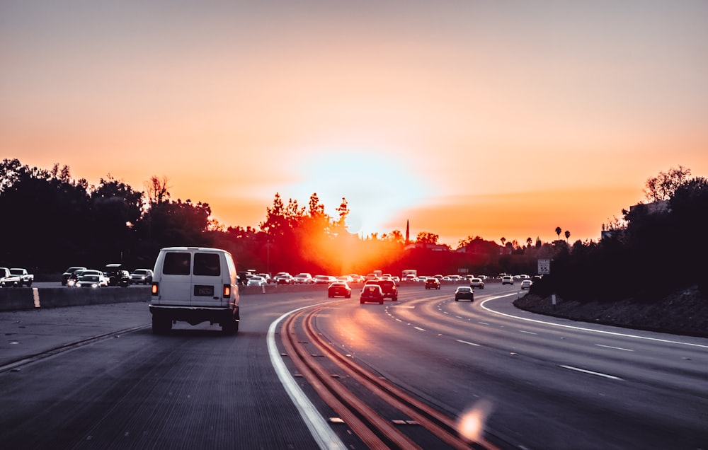 white van on grey concrete road during golden hour