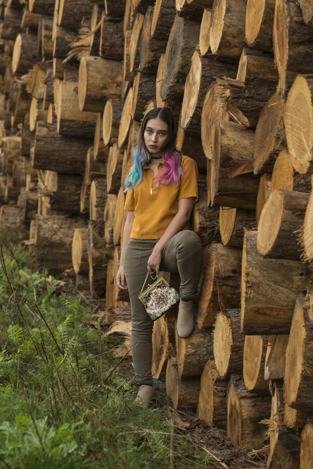 woman standing beside tree logs