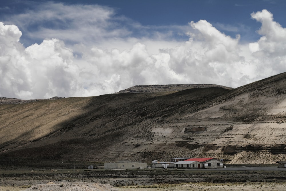 maison en béton blanc près des montagnes sous les nuages blancs