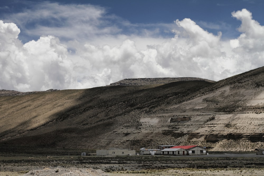 casa de hormigón blanco cerca de las montañas bajo nubes blancas