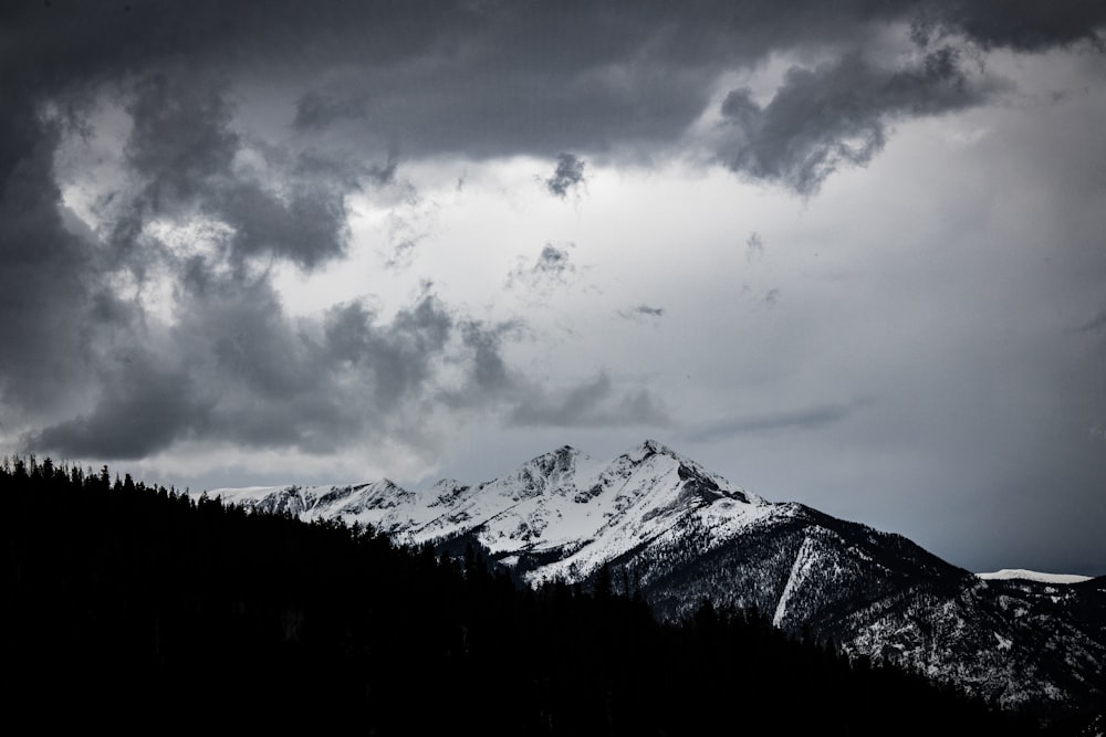 snow capped mountains under gray skies