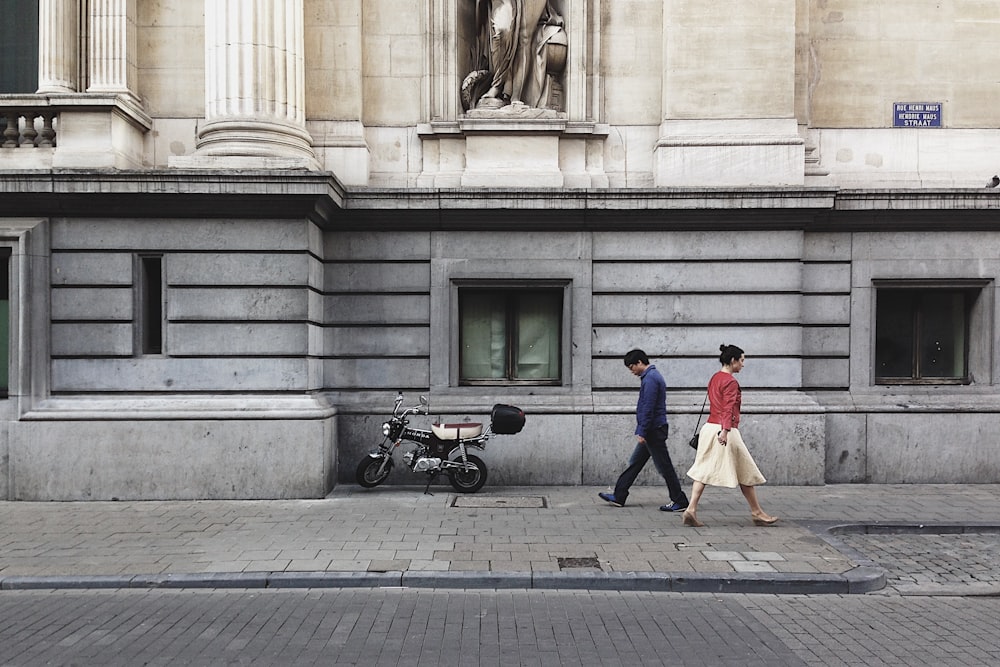 hombre caminando pasando a través de la mujer con top rojo