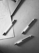 Technical file documents spread out with a pen and laptop nearby.