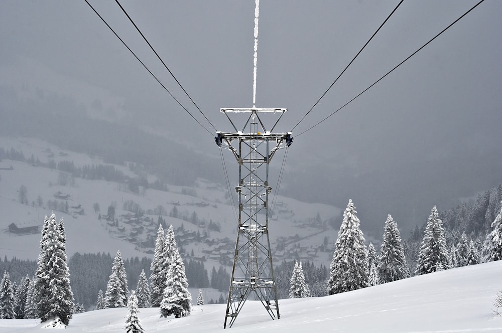 雪に覆われた黒い金属製の送電線