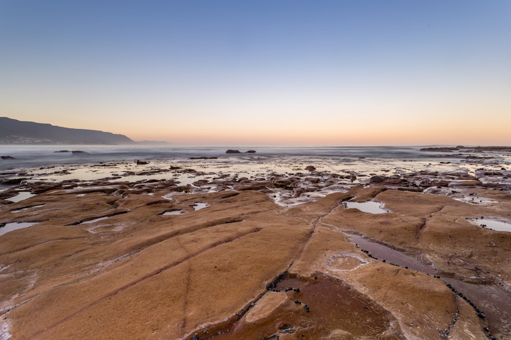 photo de paysage de terre près d’un plan d’eau