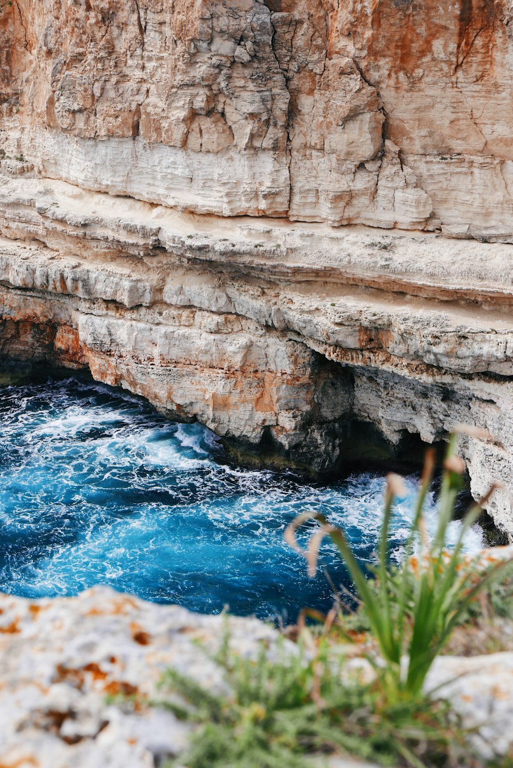 body of water near mountain cliff