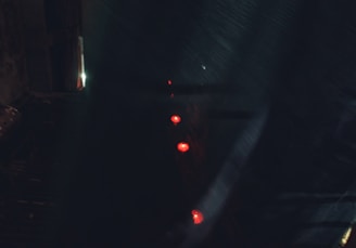 A shadowy, high-security Umbrella Corp. facility bathed in red emergency lights at night.