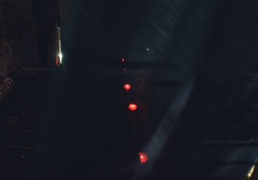 A shadowy, high-security Umbrella Corp. facility bathed in red emergency lights at night.