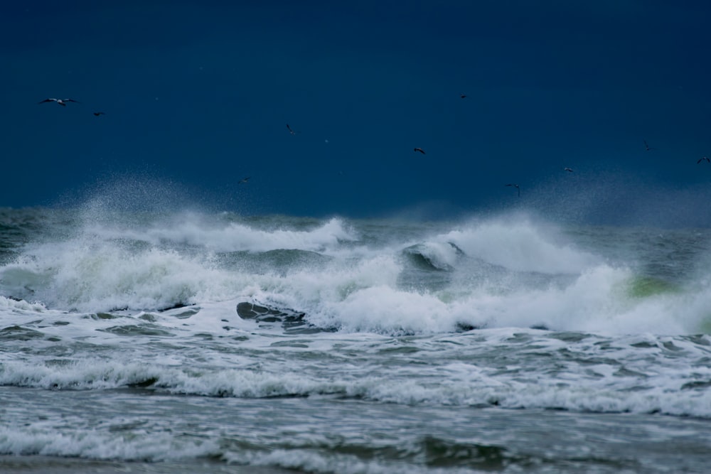 photo of sea waves rushing in to the shore