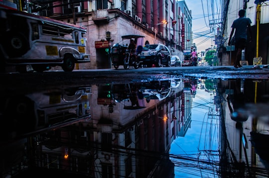 photo of person standing near vehicle and buildings in Metro Manila Philippines