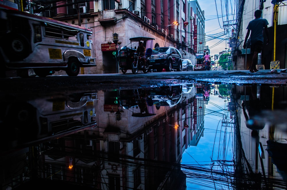 photo of person standing near vehicle and buildings