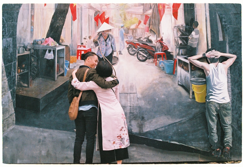 photo of man and woman hugging each other front of wall art