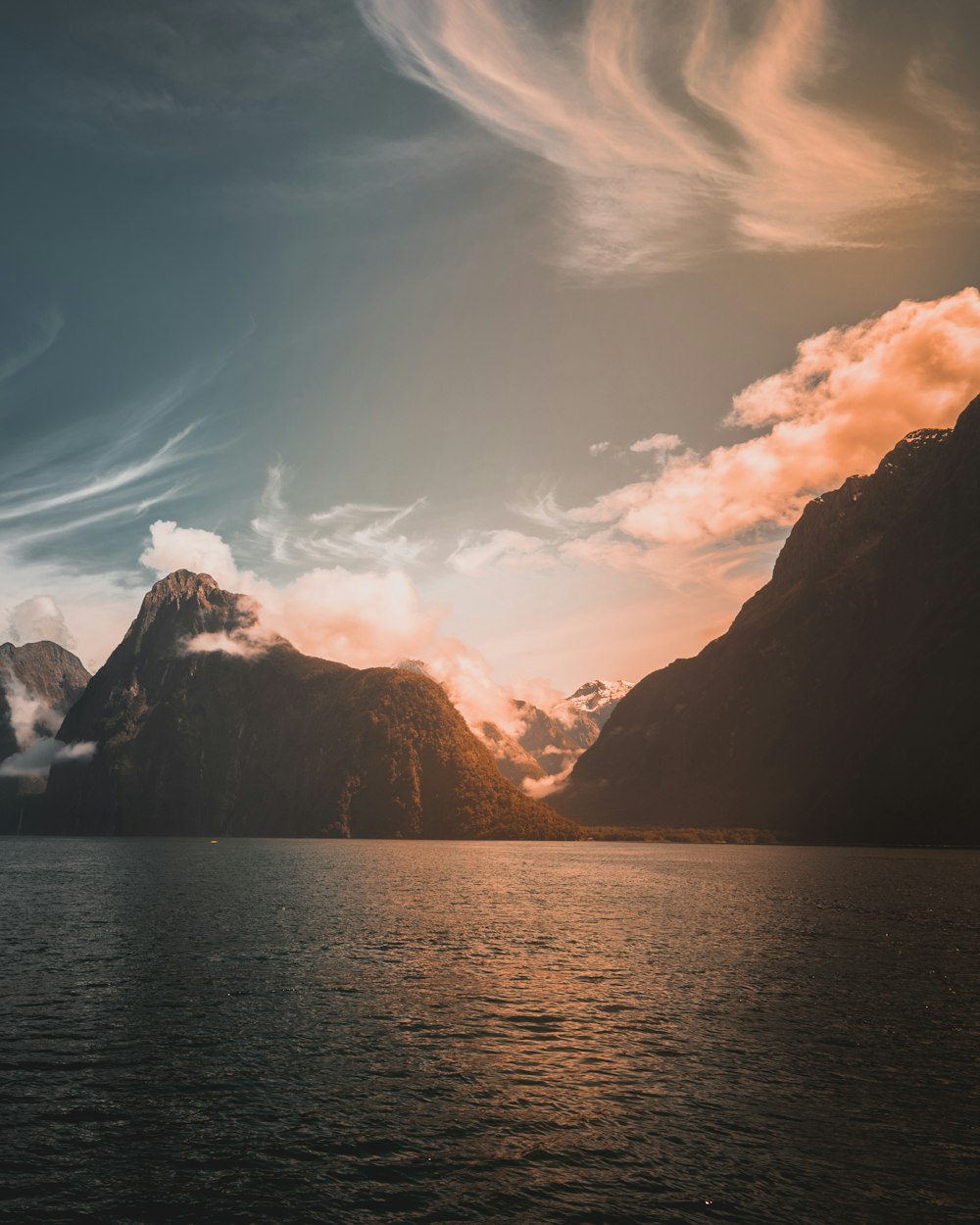 mountains near body of water during golden time