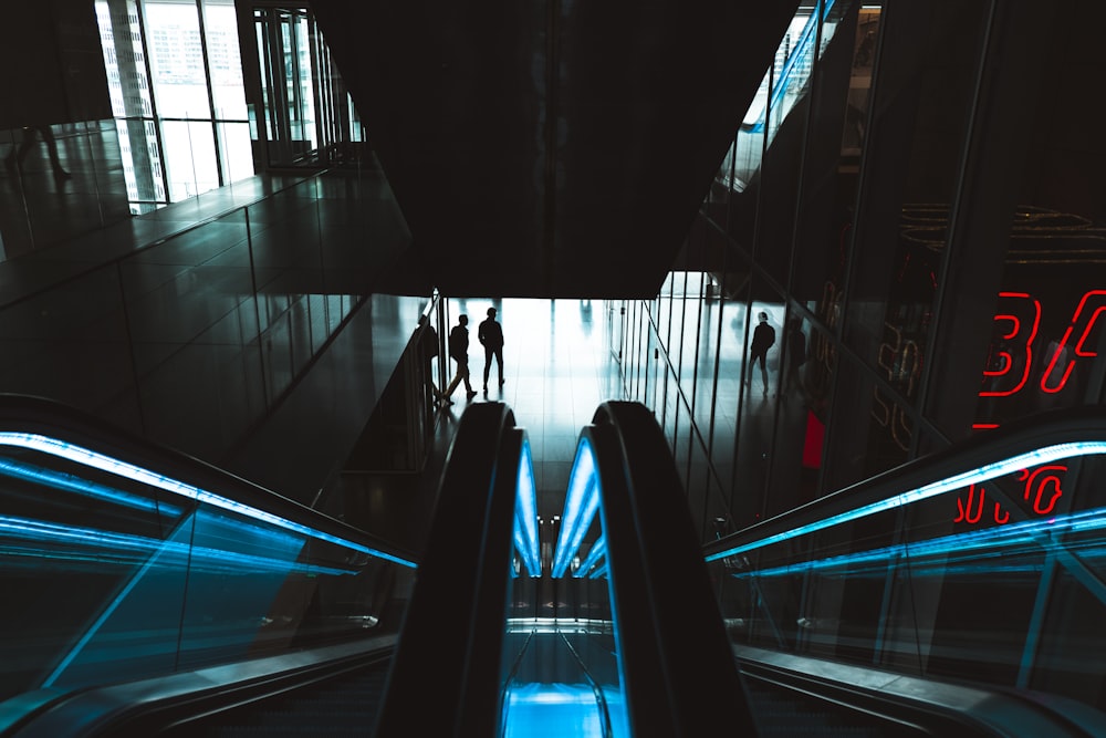 person standing near empty escalator