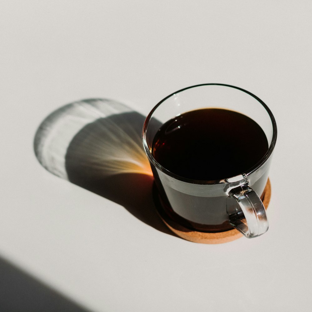 clear glass mug filled with brown liquid