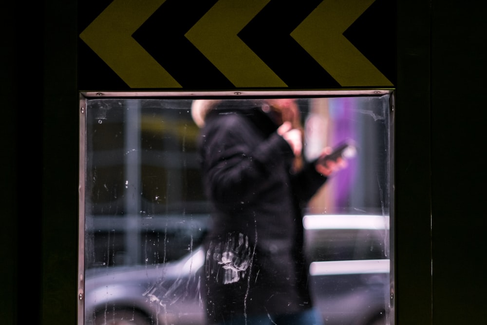man using smartphone while wearing black jacket