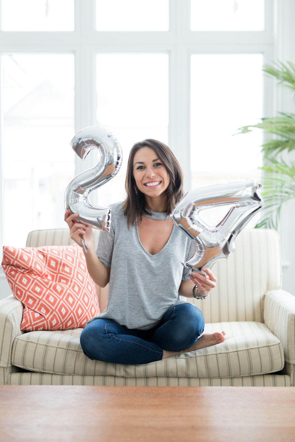 woman holding silver number balloons
