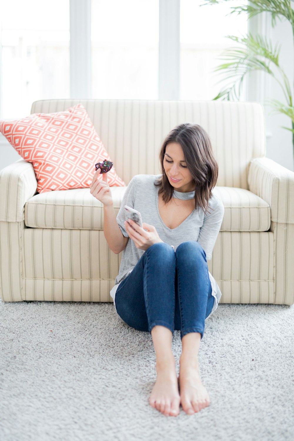 woman sitting on carpet leaning on couch