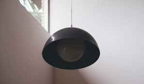 A sleek modern pendant light casting soft light over a minimalist kitchen island.