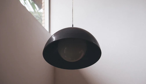 A sleek modern LED pendant light illuminating a minimalist living room.