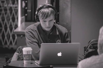 A focused writer working late at night with a laptop and a cup of coffee nearby.