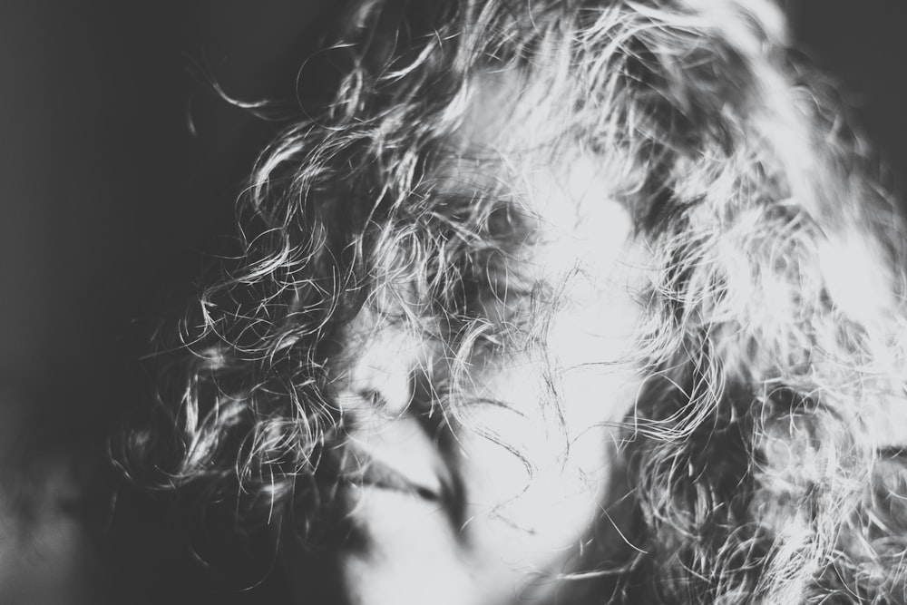 Fotografía en escala de grises de la cara de una mujer cubierta con su cabello