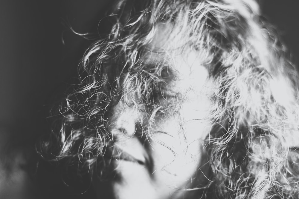 grayscale photography of a woman's face covered with her hair