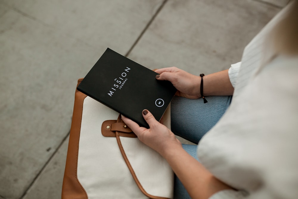 mulher segurando livro de missão preto