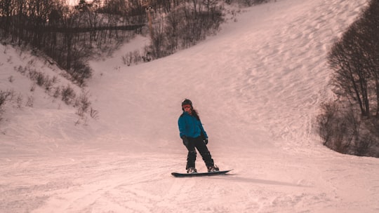 snowboarder standing on snow covered mountain in Hakuba Japan